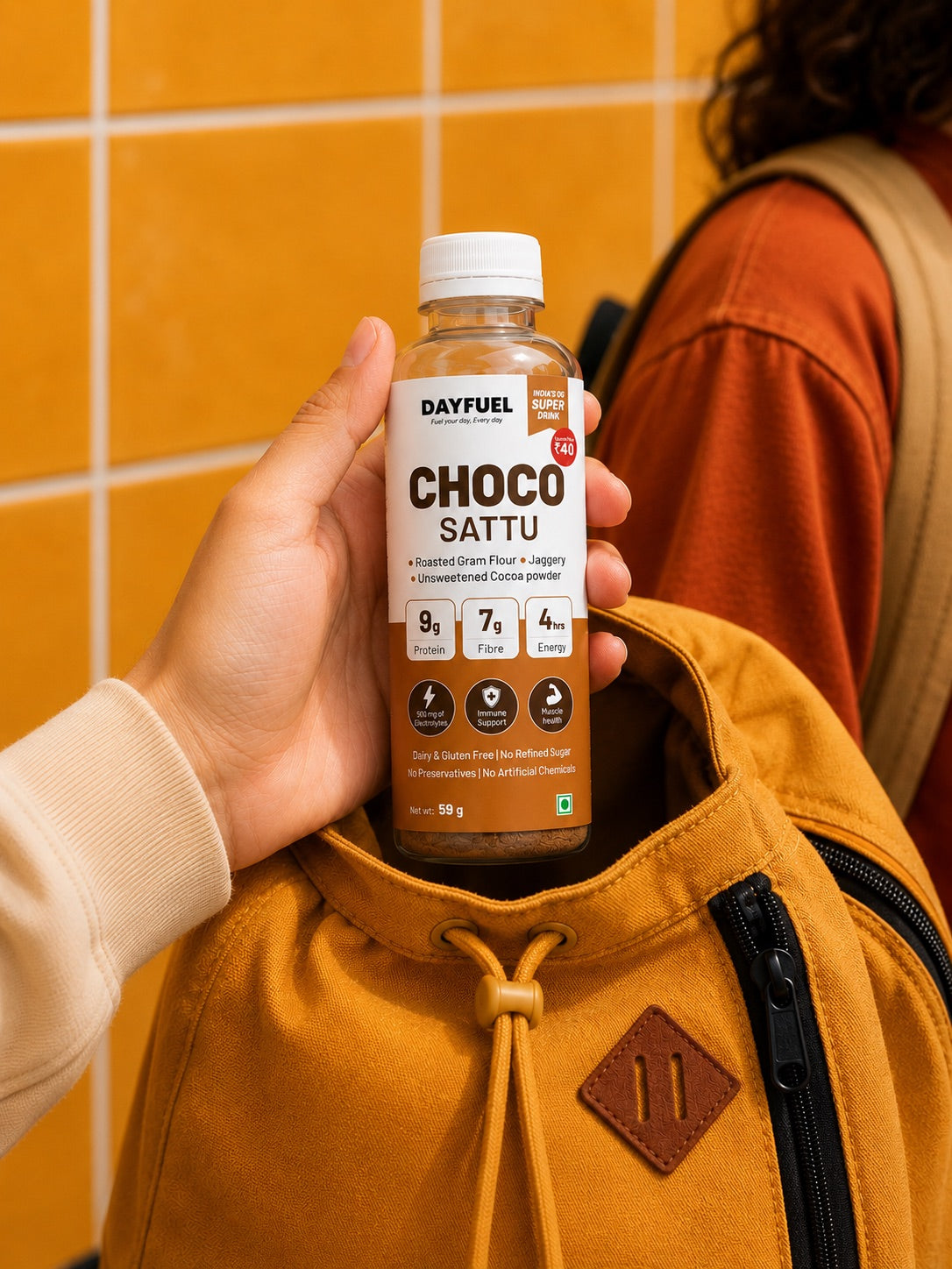 A bottle of Dayfuel Choco Sattu being slipped into the front pocket of a school backpack